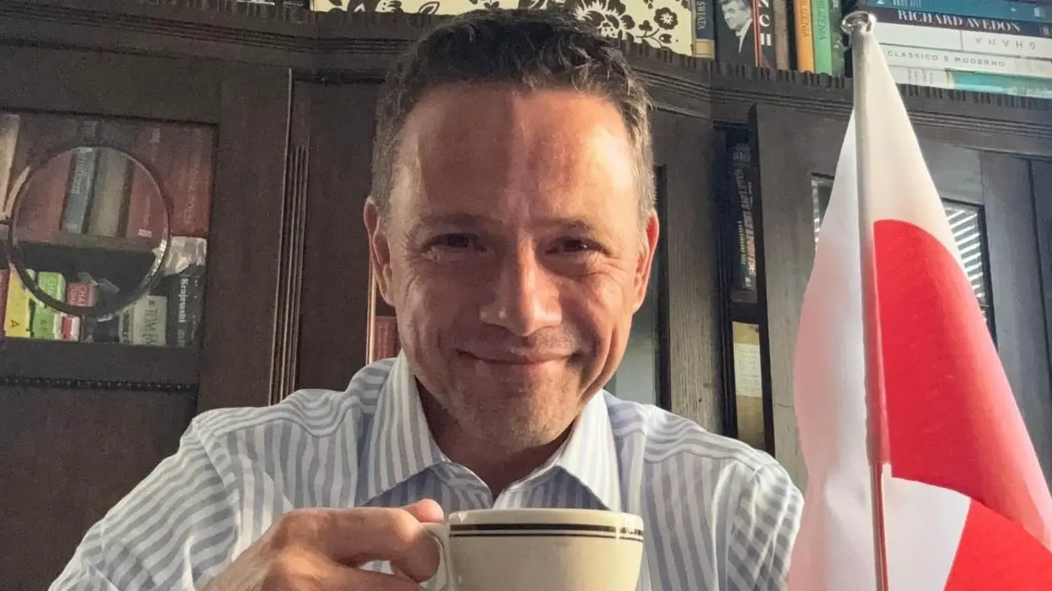 Rafał Trzaskowski pije kawę z Flagą Polski