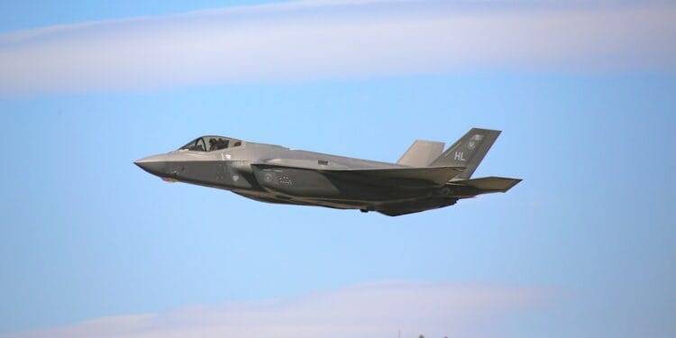 a fighter jet flying through a blue sky