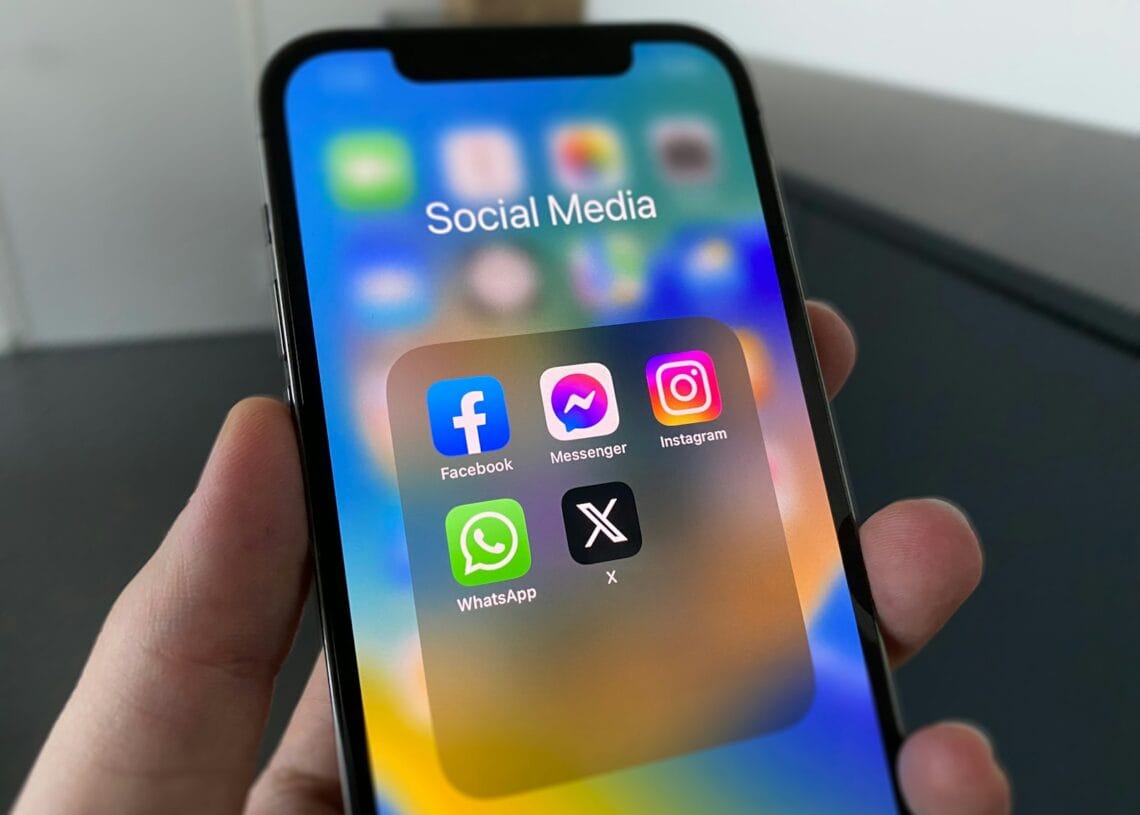 a person holding a cell phone with social media on the screen