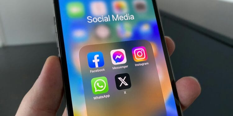 a person holding a cell phone with social media on the screen