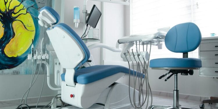 a dentist chair in a room with a painting on the wall