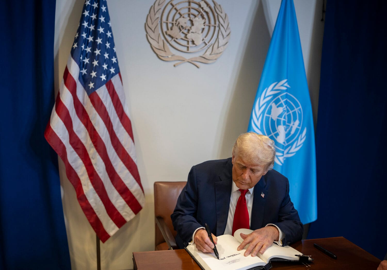 President Donald Trump signs the guest book at a bilateral meeting with U.N. Secretary General