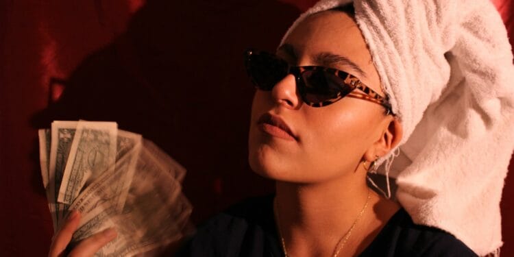 a woman with a towel on her head holding cash