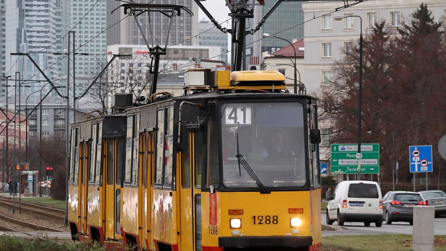 Żółto-czerwony tramwaj linii 41 jadący al. Niepodległości w Warszawie, w pobliżu siedziby GUS.