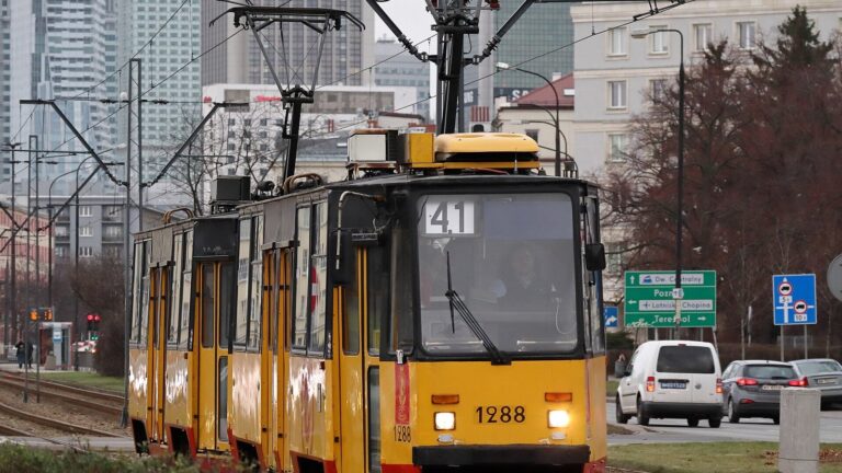 Żółto-czerwony tramwaj linii 41 jadący al. Niepodległości w Warszawie, w pobliżu siedziby GUS.