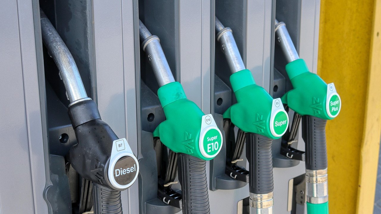 Dystrybutory paliw na stacji: czarny pistolet z napisem „Diesel” i zielone pistolety oznaczone „Super E10” oraz „Super Plus”.
