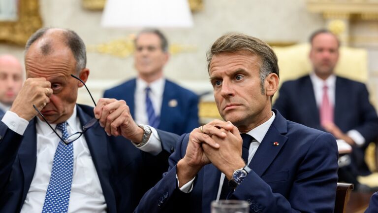 Friedrich Merz i Emmanuel Macron siedzą podczas spotkania z Donaldem Trumpem w Białym Domu, w sierpniu 2025 roku.