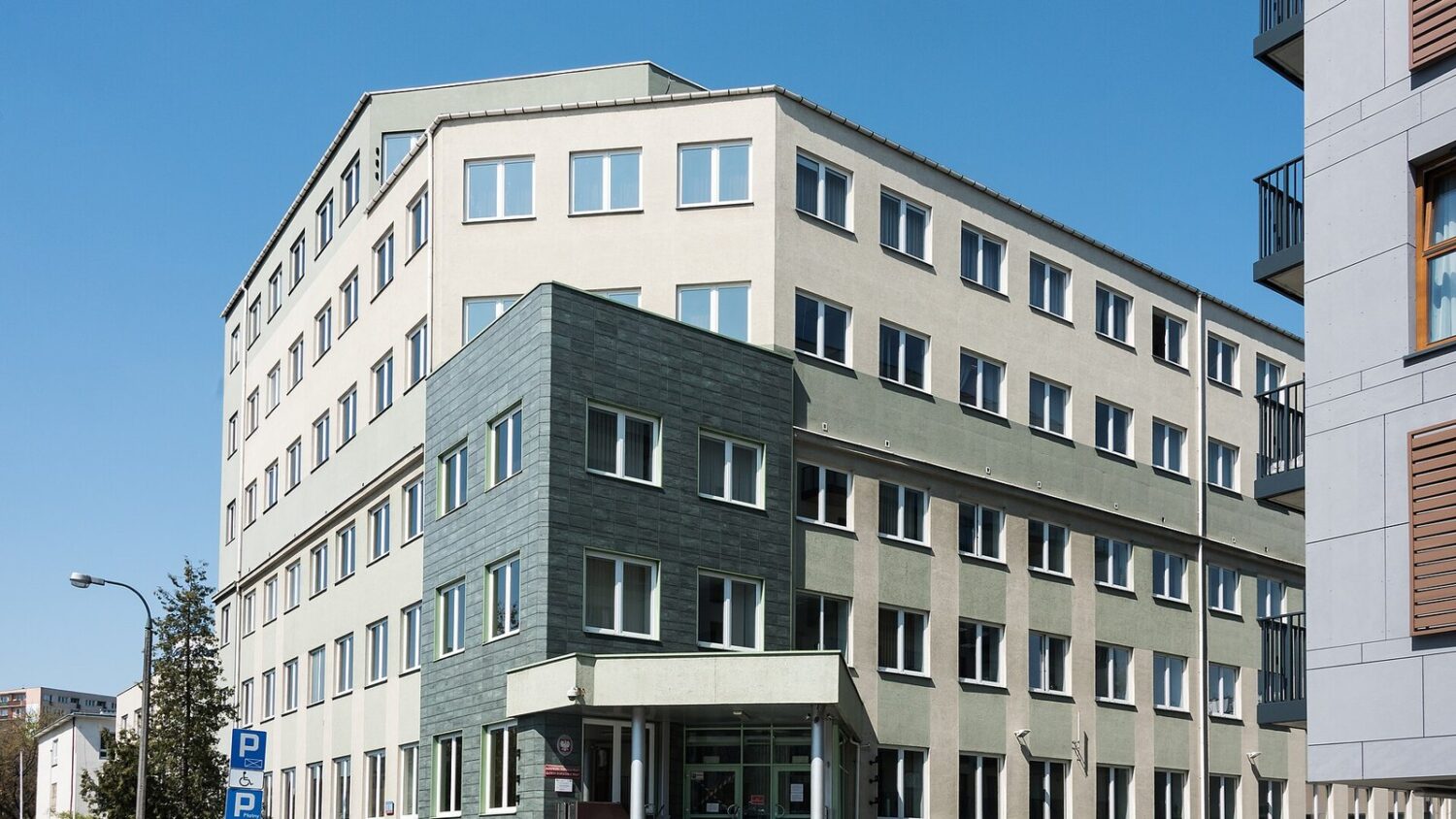 Budynek siedziby Państwowej Inspekcji Pracy przy ul. Barskiej w Warszawie, widok z ulicy w słoneczny dzień