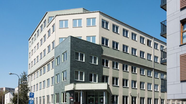 Budynek siedziby Państwowej Inspekcji Pracy przy ul. Barskiej w Warszawie, widok z ulicy w słoneczny dzień